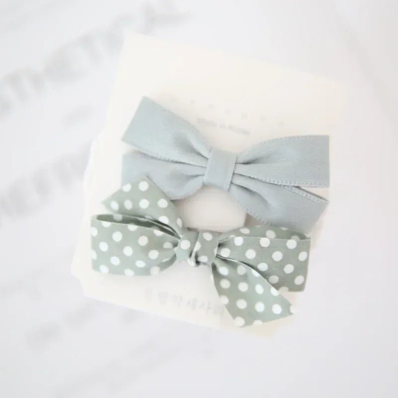 Blue pet hair bow clips from Pet Panache Boutique, decorative accessories for dogs and cats with colorful bow designs.