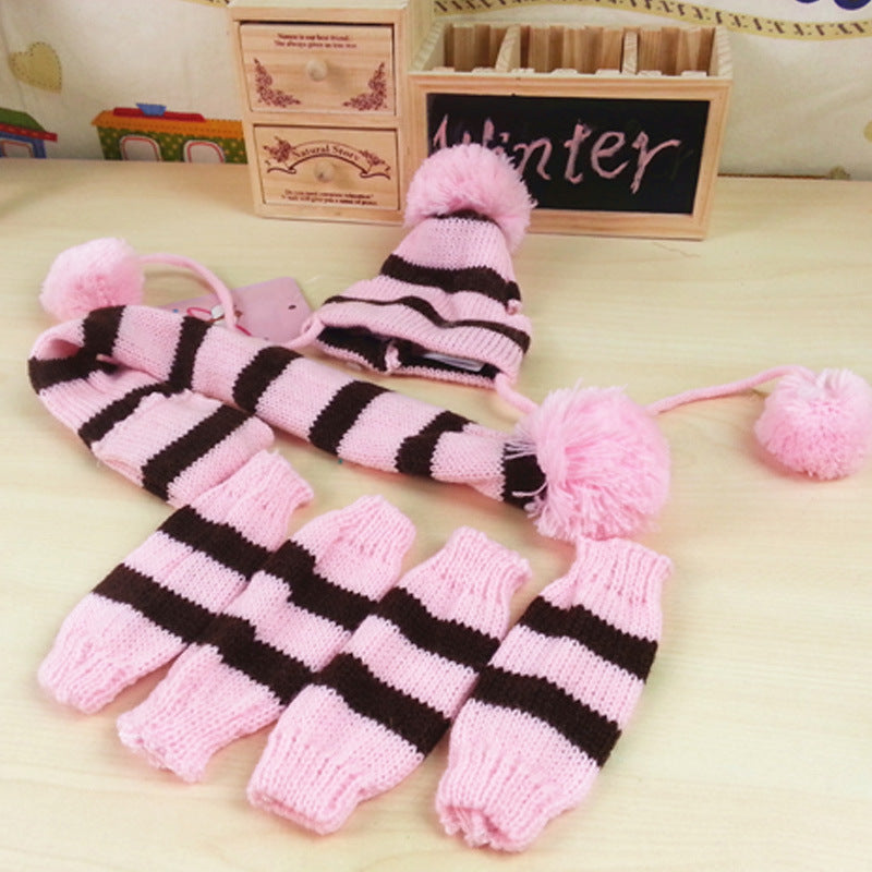 Pink and black striped pet hat, scarf, and leg warmers set with pom-poms for winter warmth and style