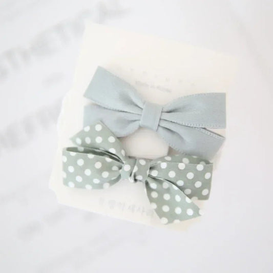 Blue pet hair bow clips from Pet Panache Boutique, decorative accessories for dogs and cats with colorful bow designs.