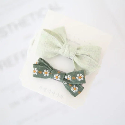 Daisy pet hair bow clips by Pet Panache Boutique featuring white daisies with yellow centers for dogs or cats.