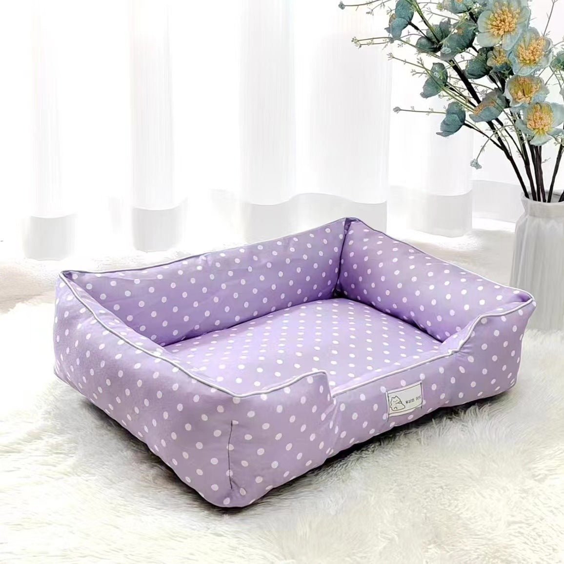 Purple polka dot pet bed from Pet Panache Boutique with soft fabric and cushioned interior for comfort.