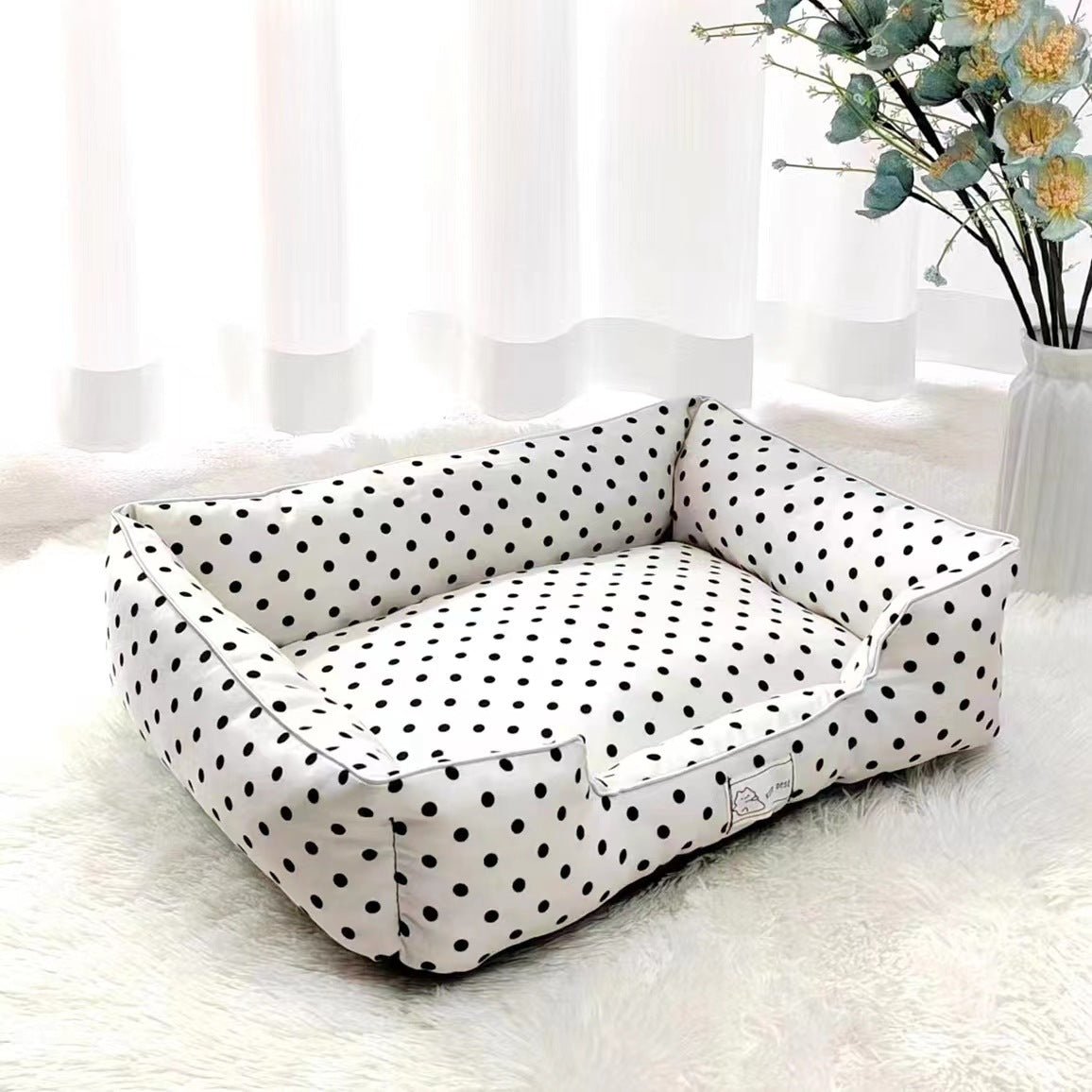 White polka dot pet bed by Pet Panache Boutique featuring soft fabric and cozy cushioning for small pets.